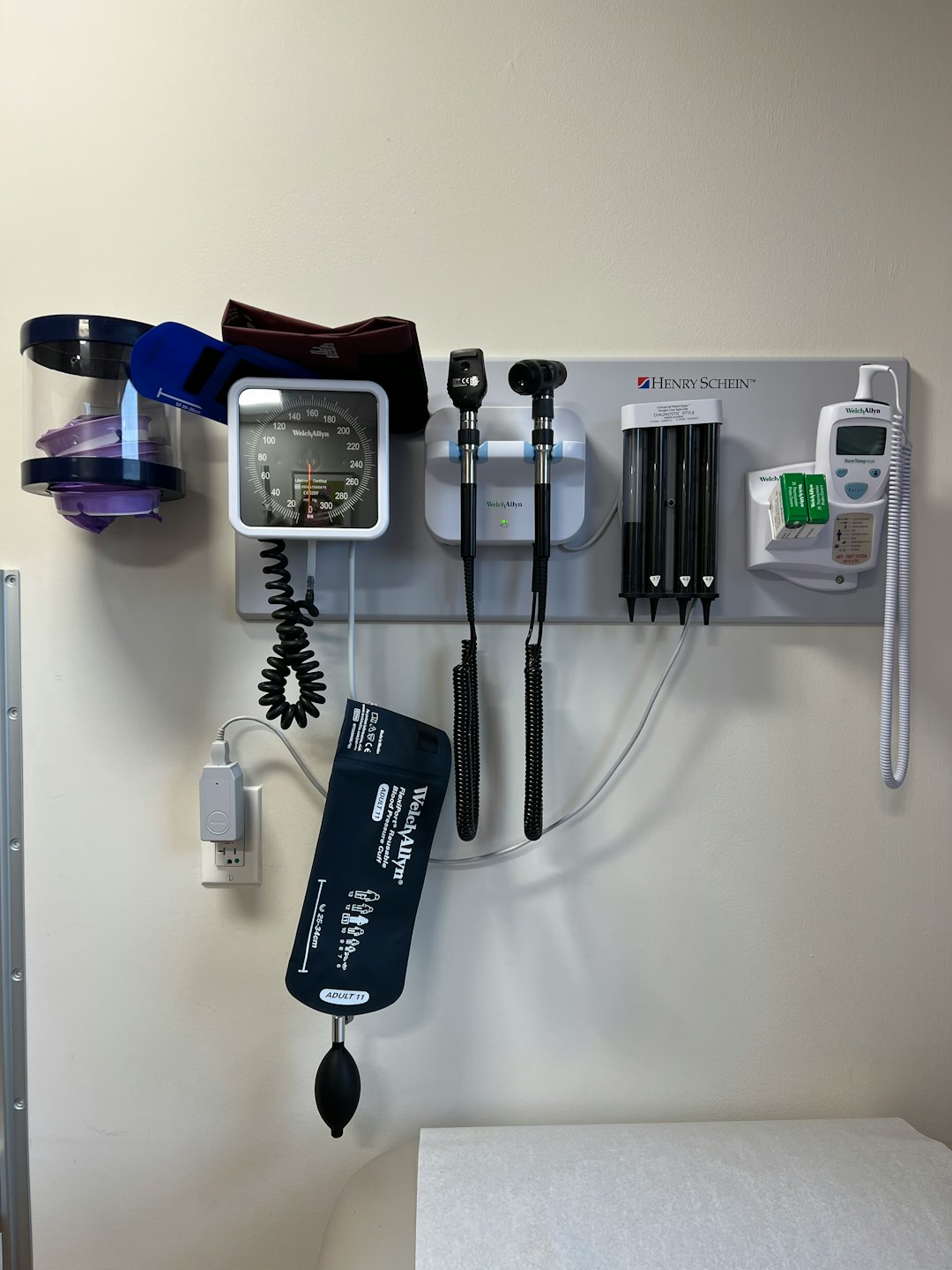 An der Wand montierte medizinische Diagnosestation mit Blutdruckmessgerät und Untersuchungswerkzeugen.