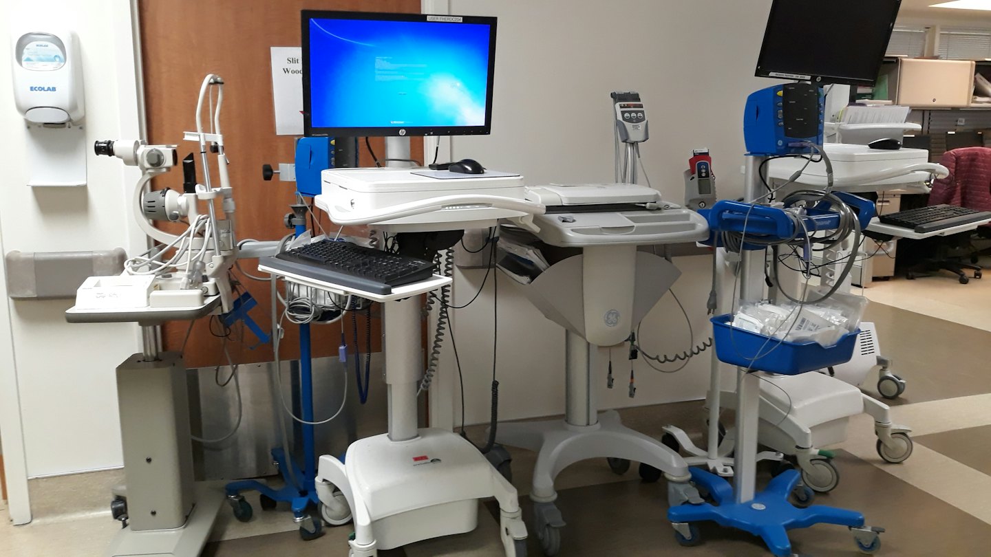 Medizinische Geräte auf Rollwagen in einem Klinikflur.